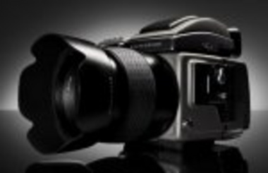 Sorthvidt foto af et professionelt kamera med en stor linse.